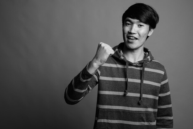 Young Asian man wearing striped hoodie