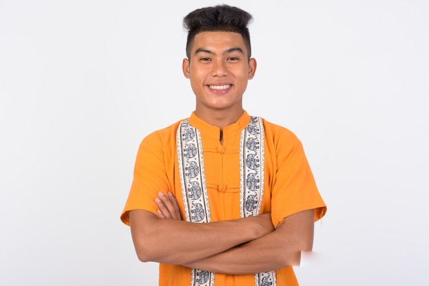 Молодой азиатский мужчина в традиционной одежде у белой стены