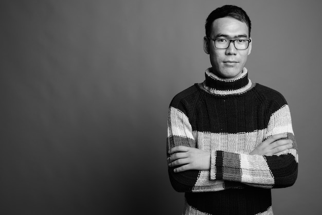 Young Asian man wearing turtleneck sweater and eyeglasses