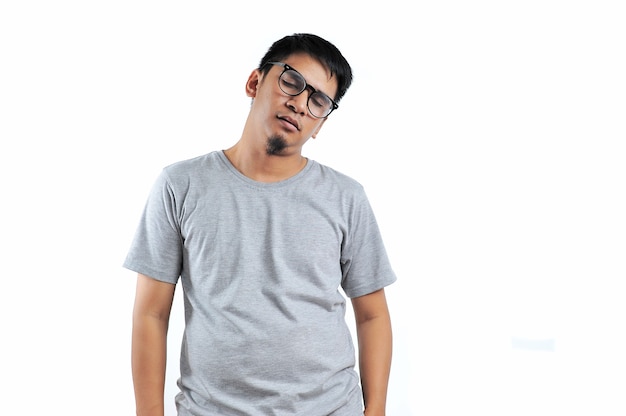 Молодой азиатский мужчина с серой футболкой чувствует себя измученным, изолированным на белом фоне