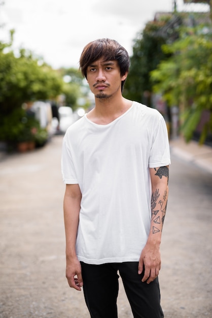 Молодой азиатский мужчина с татуировками на улицах