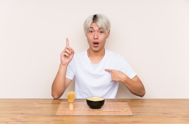 驚きの表情を持つテーブルで抹茶と若いアジア人