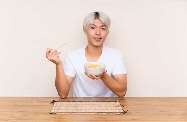 Young asian man with ramen in a table