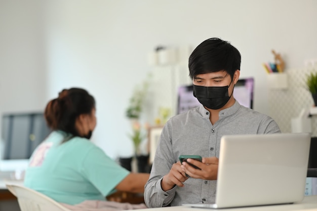 Young Asian man working on a laptop at his desk