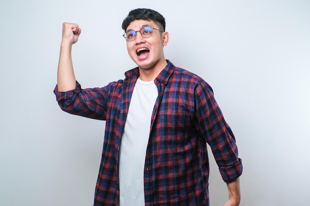 Young asian mandoing winner gesture with arms raised smiling and screaming for success Celebration concept