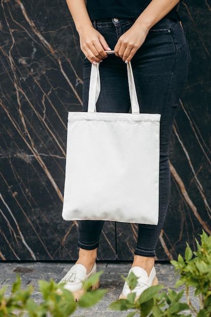 Young asian model girl on the street holding white eco bag mock up