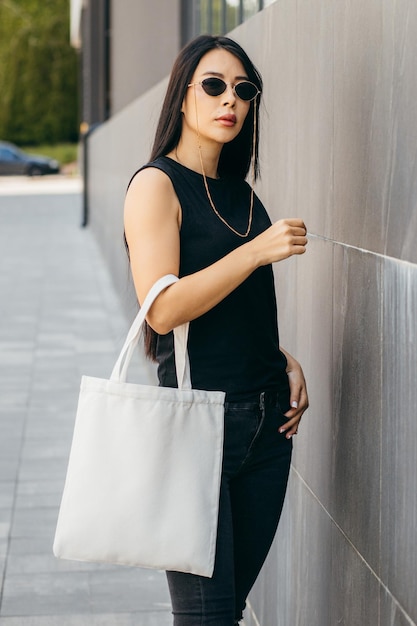 Photo young asian model girl on the street holding white eco bag mock up