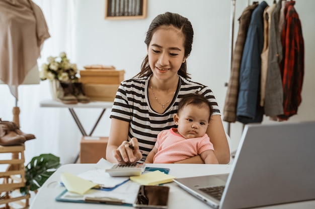 Young asian mom working from home with her daughter