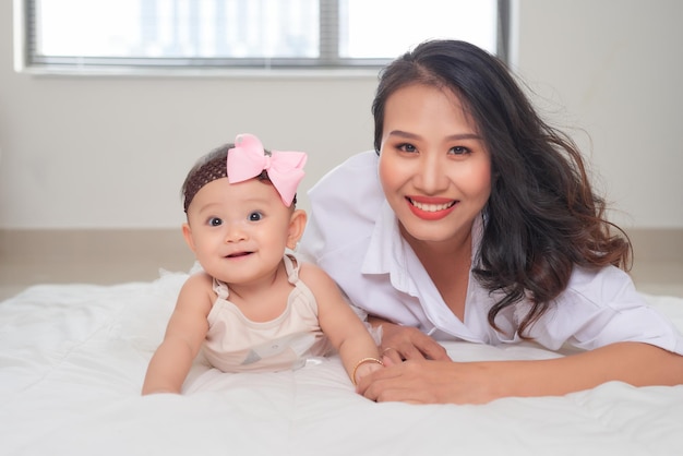 Young asian mother and baby lying on floor