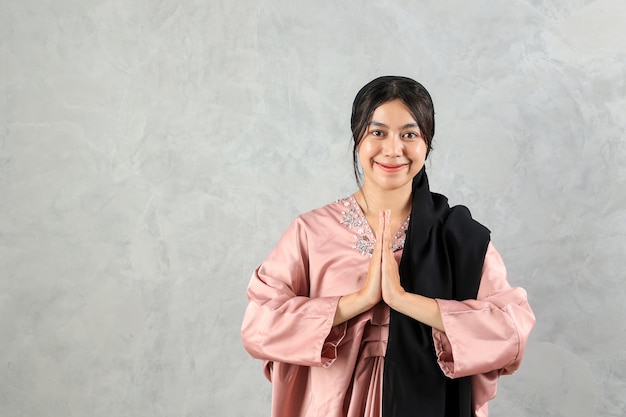 Young Asian Muslim Female Gesturing Eid Mubarak Greeting