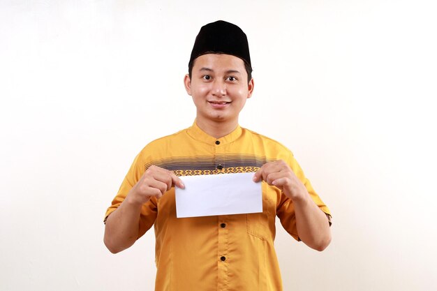 Young Asian muslim man holding an envelope filled with money Give THR or Zakat Fitrah as an obligation in the holy month of Ramadan