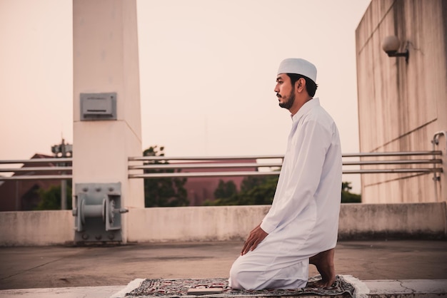 A Young asian muslim man praying on sunsetRamadan festival concept