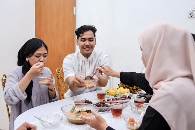 Young asian muslim people having dinner break fasting together at home during ramadan