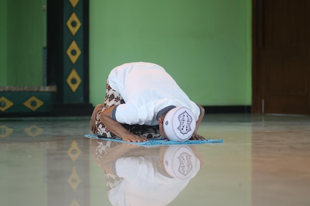 Young asian muslim praying in the mosque