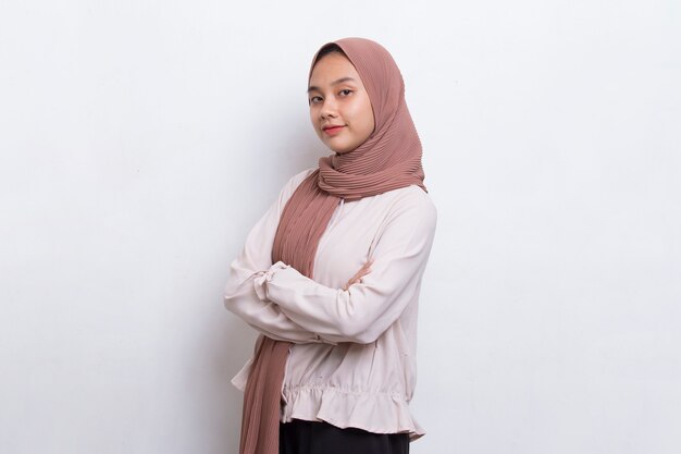 Young asian muslim woman in head scarf smile with arms crossed on white background