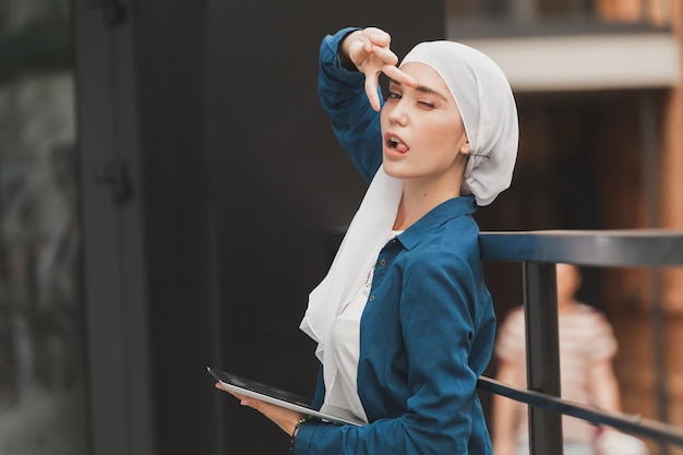 Young asian muslim woman in head scarf smile with mobile tablet and copyspace