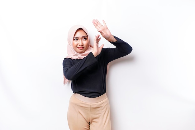 Young Asian Muslim woman isolated on white background looks depressed face covered by arms frightened and nervous