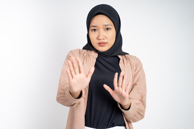 Giovane donna musulmana asiatica che rifiuta con il gesto di entrambi i palmi