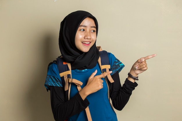 Young asian muslim woman traveler wearing hijab smiling confident pointing with fingers to different directions.