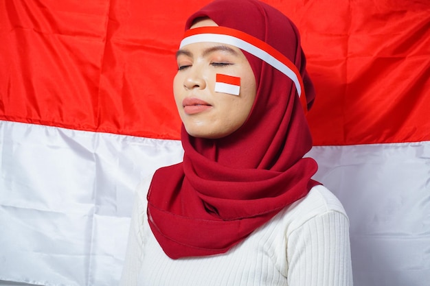 Young Asian Muslim Women Celebrate Indonesian independence day with Red and white flag background