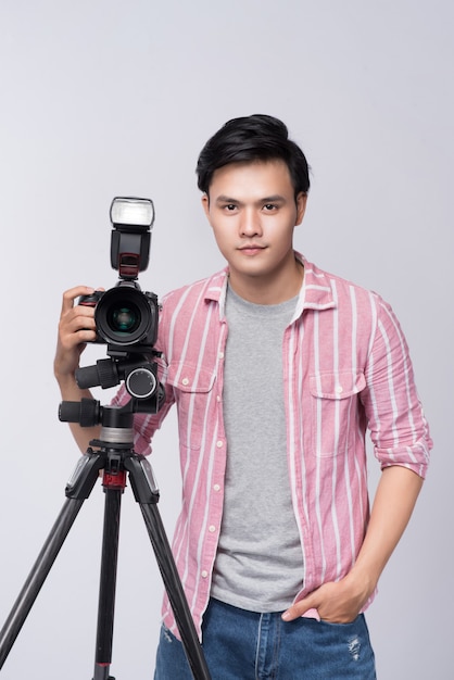 Young asian photographer holding digital camera, while working in studio