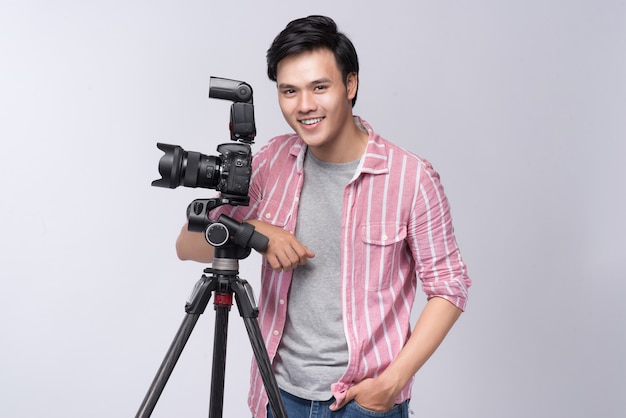 Young asian photographer holding digital camera, while working in studio