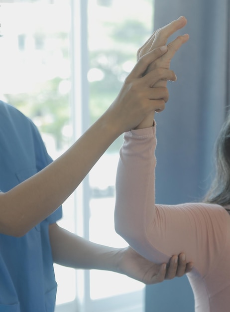 사진 워커와 함께 걷는 수석 여성과 함께 일하는 젊은 아시아 물리 치료사