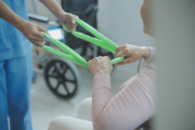 사진 워커와 함께 걷는 수석 여성과 함께 일하는 젊은 아시아 물리 치료사