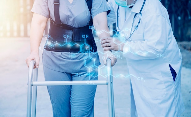 Young asian physical therapist working with senior woman on walking with a walker