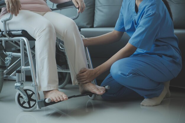 Young asian physical therapist working with senior woman on walking with a walker