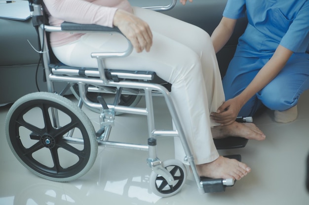 Young asian physical therapist working with senior woman on walking with a walker