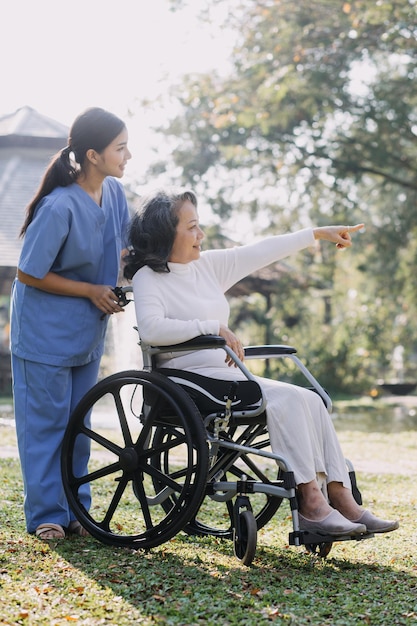 Young asian physical therapist working with senior woman on walking with a walker