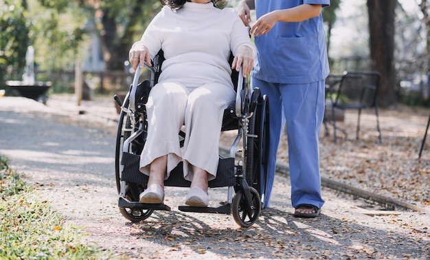 Young asian physical therapist working with senior woman on walking with a walker