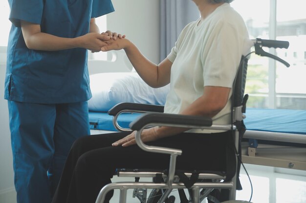 Young asian physical therapist working with senior woman on walking with a walker