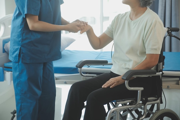 Young asian physical therapist working with senior woman on walking with a walker