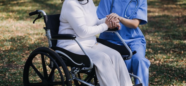 Young asian physical therapist working with senior woman on walking with a walker