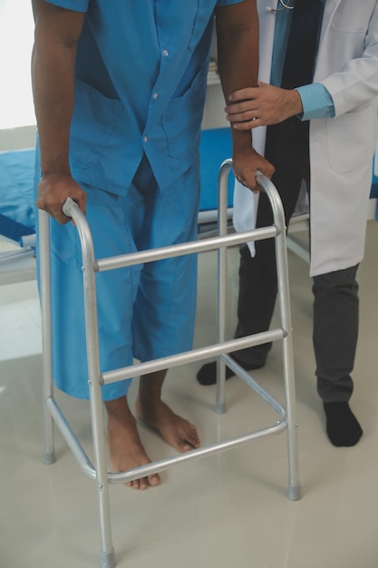 Foto giovane fisioterapista asiatico che lavora con una donna senior mentre cammina con un deambulatore