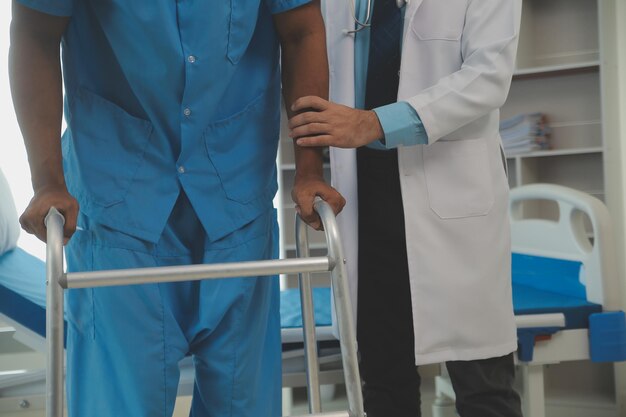 young asian physical therapist working with senior woman on walking with a walker