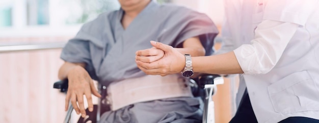 Photo young asian physical therapist working with senior woman on walking with a walker