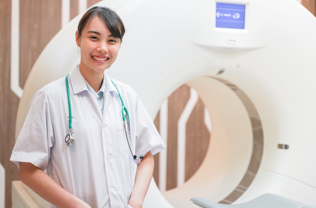 Фото Молодой азиатский врач-резидент с компьютерной томографией (кт), медицинская концепция