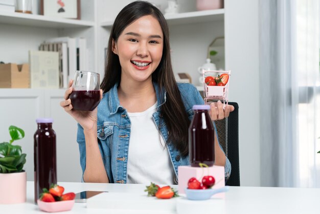 Young Asian reviewing tasty mixed strawberry and cherry juice drinks Stratagem