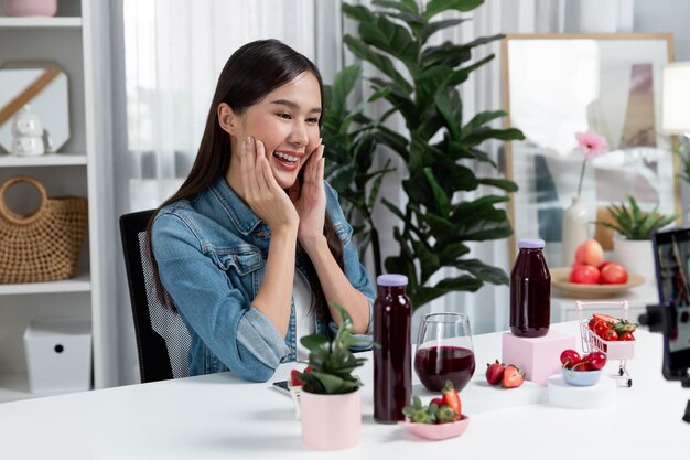 Photo young asian reviewing tasty mixed strawberry and cherry juice drinks stratagem