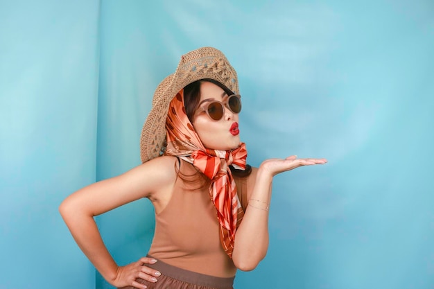 Young Asian shocked woman isolated by a blue background pointing copy space on the side