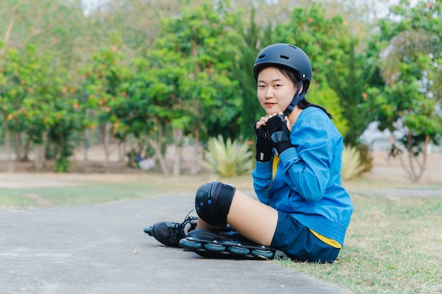Giovane pattinatore asiatico che indossa pattino in linea e set di sicurezza, persone nel concetto di attività e tempo libero.