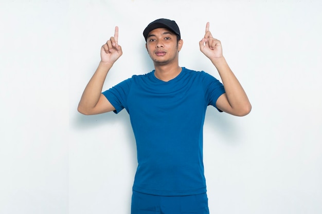 Young asian sporty man pointing finger on empty space on white background