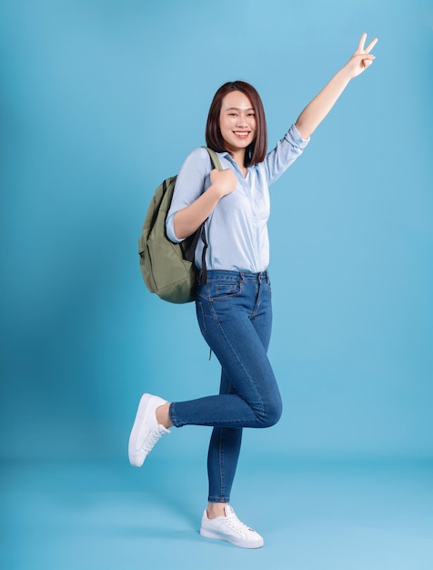 Young Asian student on blue background