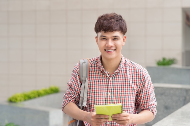 Young asian student inside university building