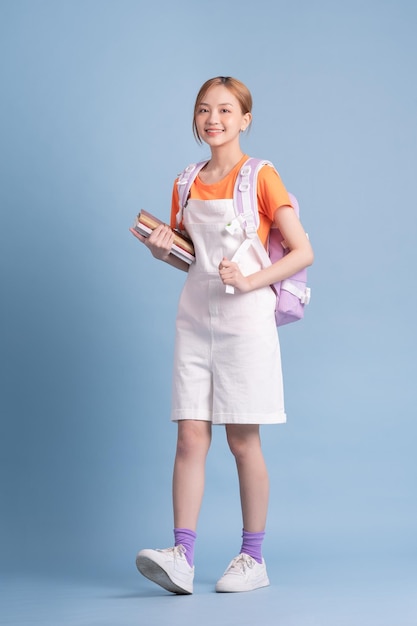 Photo young asian student posing on blue background