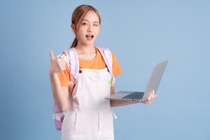 Young asian student posing on blue background