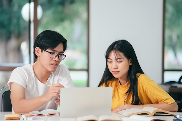 Young asian students campus helps friend catching up and learning